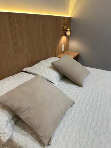a bedroom with a bed with two pillows on it at Apartamento Concierge Sensacional in Marabá