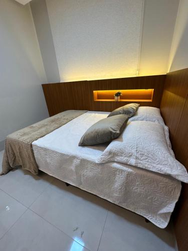 a bedroom with a large bed with a wooden headboard at Apartamento Concierge Sensacional in Marabá