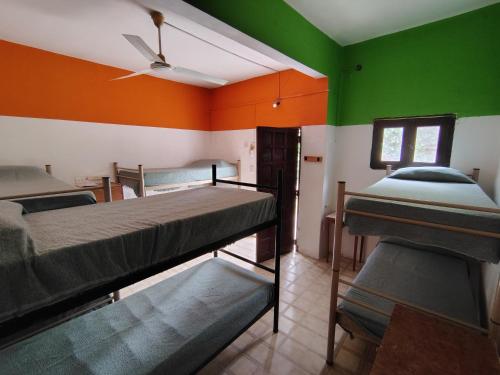 two bunk beds in a room with green and orange walls at Andamundos Hostel in Mina Clavero