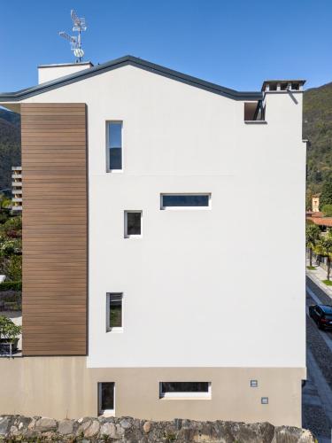 a white house with a wooden facade at Hotel Elvezia in Cannobio