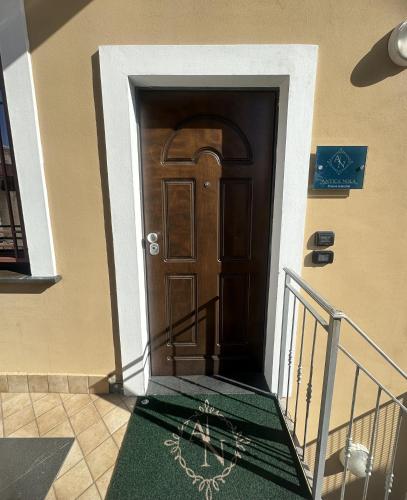 a hallway with a wooden door with a green carpet at Antica Nola - Dimora Fellecchia in Nola