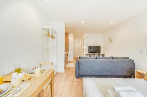 a living room with a bed and a table at Blue Charm - Campolide Apartments in Lisbon