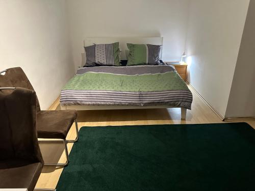 维也纳A place to relax的卧室里有一张床，铺着绿色地毯，还有一把椅子