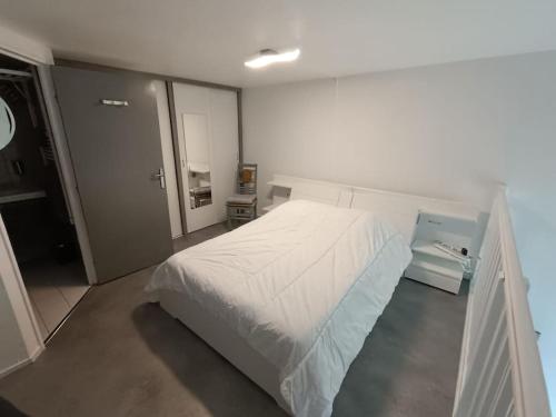 une chambre avec un grand lit blanc dans une pièce dans l'établissement Appartement Coeur de Granit Rose, à Perros-Guirec