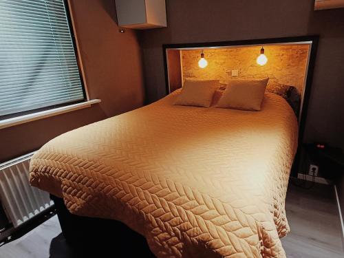 a bedroom with a large bed with two pillows at Landhuisje 31 'De Akkersteen' Bospark IJsselheide Zwolle Hattemerbroek in Hattemerbroek