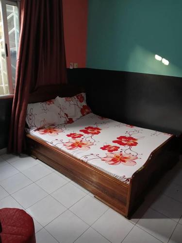 a bedroom with a bed with red flowers on it at Villa MBOLO in Pointe-Noire