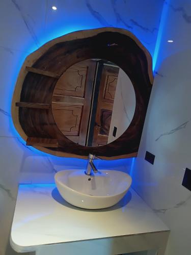 a bathroom with a sink with a wooden mirror at Athila Ecolove in Monteverde Costa Rica