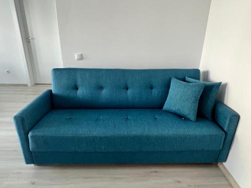 a blue couch sitting in an empty room at Blue Apartment in Floreşti