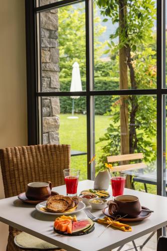 a white table with plates of food and a window at Hotel Elvezia in Cannobio