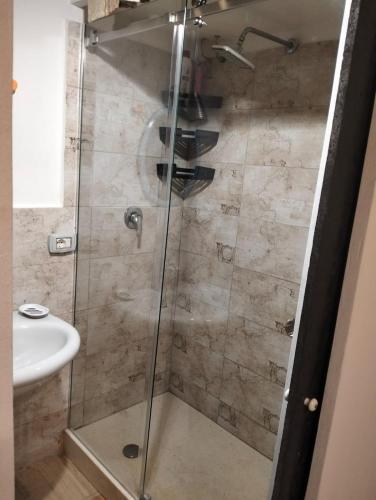 a shower with a glass door next to a sink at MuSa Apartment in Catania