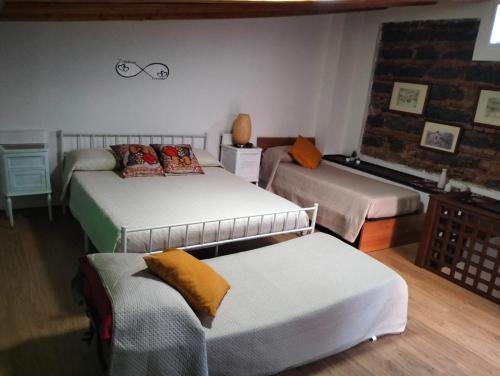 a room with three beds and a couch at MuSa Apartment in Catania