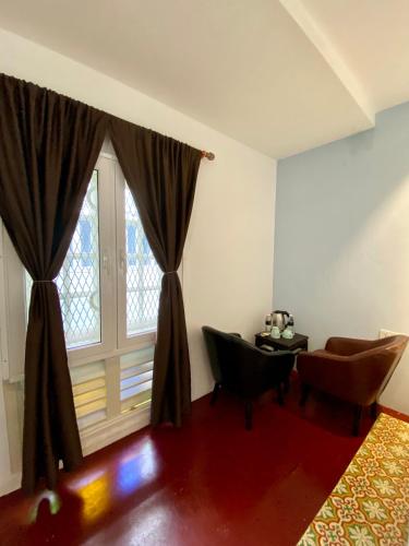 a room with a window and a chair and a table at Bayu Bayu Hotel by Soft Loft in Tanjung Bungah