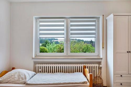 a bedroom with a window with a bed and a radiator at Ferienwohnung Wasserturmblick in Bebra