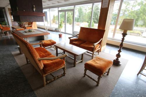 a living room with chairs and a table and a lamp at Petit havre de paix! in Les Collons