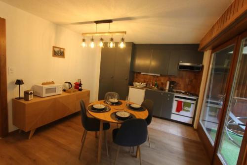 a kitchen with a table and chairs in a room at Petit havre de paix! in Les Collons
