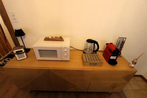 a microwave sitting on top of a counter with a telephone at Petit havre de paix! in Les Collons