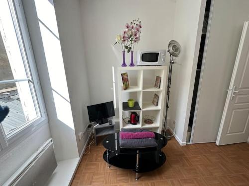 une chambre avec une chaise, une table et une télévision dans l'établissement Petit Studio Hyper Centre, à Grenoble