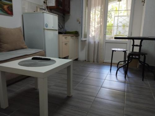 a living room with a table and a kitchen at Vila Katerina Dojran in Star Dojran