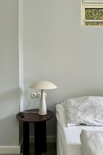 a lamp on a table next to a bed at Gesamtes Historisches Kapitänshaus in Fehmarn