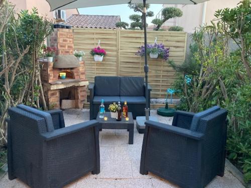 une terrasse avec 2 chaises et une table avec un parasol dans l'établissement Carro, aux couleurs de la Méditerranée, à Martigues