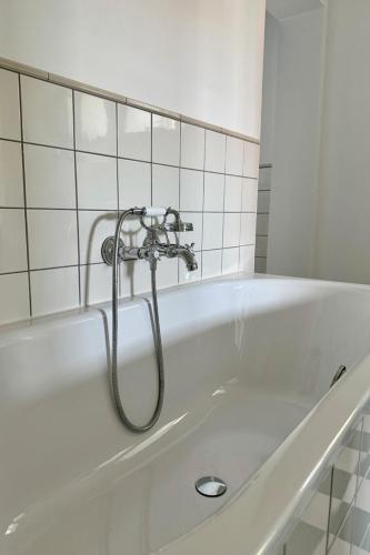 a bath tub with a shower in a bathroom at Gesamtes Historisches Kapitänshaus in Fehmarn