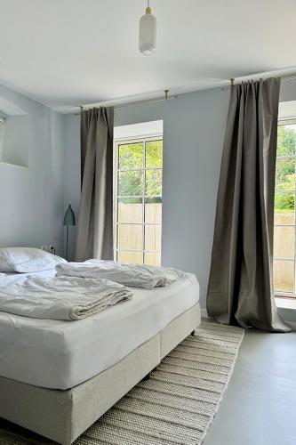 a bed in a bedroom with a large window at Gesamtes Historisches Kapitänshaus in Fehmarn