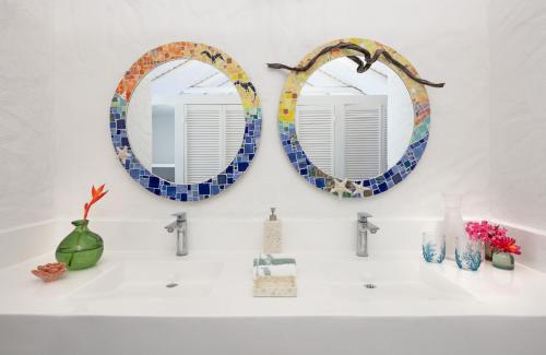 two mirrors above a sink in a bathroom at Monasterio del Viento in Bahia Maracaibo