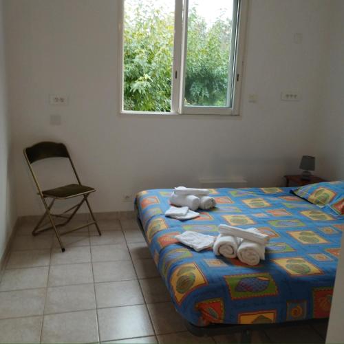 a bedroom with a bed and a chair and a window at Maison à la plage.7 couchages in Borgo