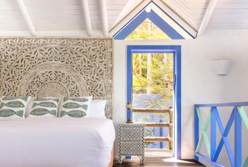 a bedroom with a bed and a blue door at Monasterio del Viento in Bahia Maracaibo
