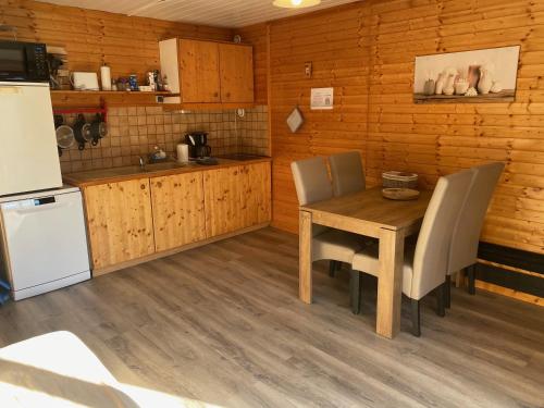 a kitchen with a table and chairs and a refrigerator at Chalet à un endroit exceptionnel, Alpes, Parc National des Ecrins in Les Vigneaux
