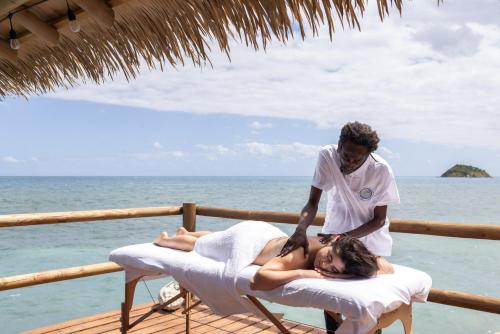 a man giving a woman a massage on the beach at Monasterio del Viento in Bahia Maracaibo