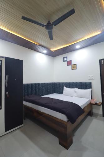 a bedroom with a bed with a ceiling fan at Ujjain Sparsh Stays in Ujjain