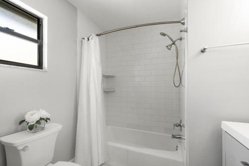 a white bathroom with a shower and a toilet at Beach Rd, 300ft to Beach Access & 500ft to Siesta Key Village, 2bdr in Siesta Key