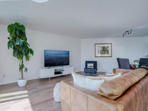 a living room with a couch and a flat screen tv at Coastal Charm - min 3-Day Stay Breathtaking Views with Work Desk by Victoria Prime! in Victoria