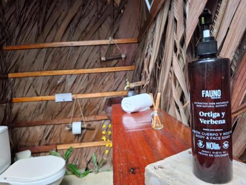 a bathroom with a toilet and a large bottle of shampoo at Mangle House Cabañas Ladrilleros in Buenaventura