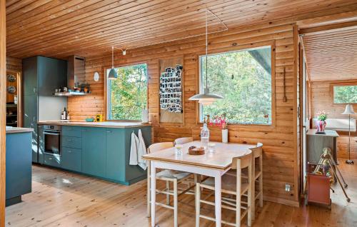 a kitchen with a table in a room with wooden walls at Cozy Home In Stege With Wifi in Stege