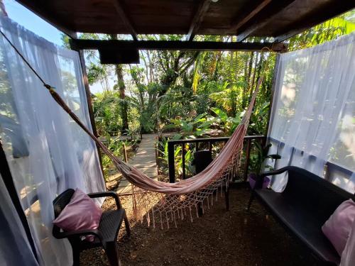 a hammock on the porch of a house at Mangle House Cabañas Ladrilleros in Buenaventura
