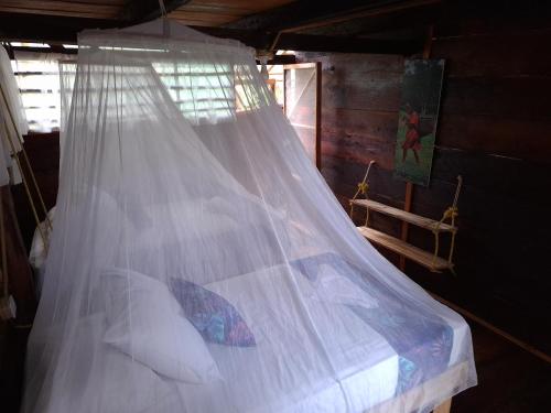 a bed with a mosquito net in a room at Mangle House Cabañas Ladrilleros in Buenaventura