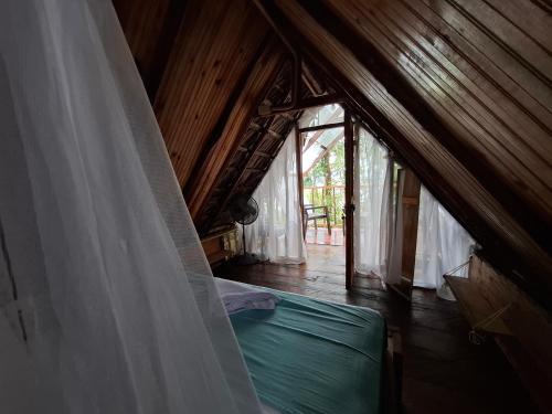 a bedroom with a bed in a wooden house at Mangle House Cabañas Ladrilleros in Buenaventura