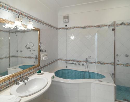 a bathroom with a tub and a sink and a shower at Hotel Villa Brunella in Capri