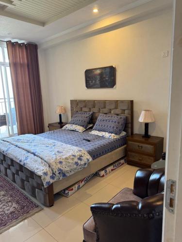 ein Schlafzimmer mit einem großen Bett und einem Stuhl in der Unterkunft Serenity Suites in Bhurban