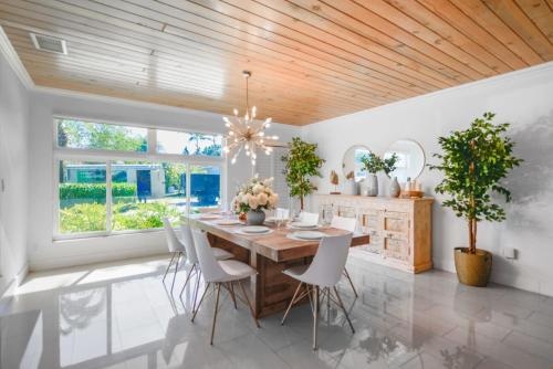 a dining room with a wooden ceiling and a table and chairs at Charming House with Private Pool n Coral Gable in Miami