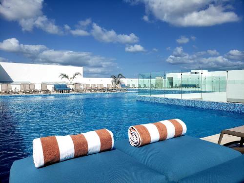 une piscine avec deux chaises longues à côté dans l'établissement Ipana Condos by HA, à Playa del Carmen