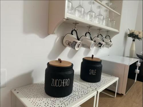 two black containers sitting on a table in a kitchen at LOFT SUL FIUME center home in Ascoli Piceno