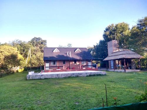 a house with a large yard and a gazebo at Los Laureles de Sorso in Villa Ciudad Parque