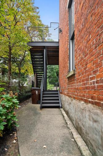 a brick building with a stairway leading into a building at Pastel Paradise - Adorable Covington Apartment in Covington