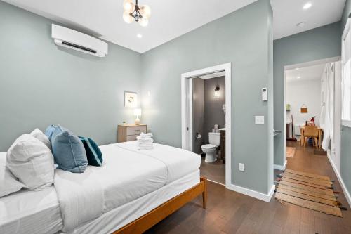 a bedroom with a white bed and a bathroom at Pastel Paradise - Adorable Covington Apartment in Covington