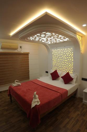 a bedroom with a large bed with red pillows at Vaishnav Tours in Alleppey