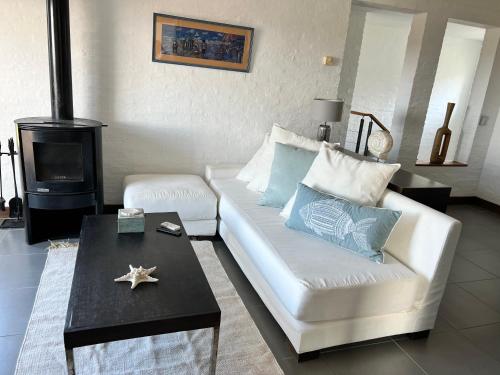 a living room with a white couch and a stove at IPB la Juanita Oeste in José Ignacio