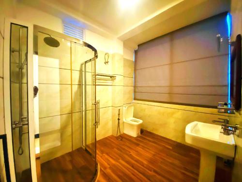a bathroom with a shower and a sink and a toilet at Hotel Rosenro in Piliyandala
